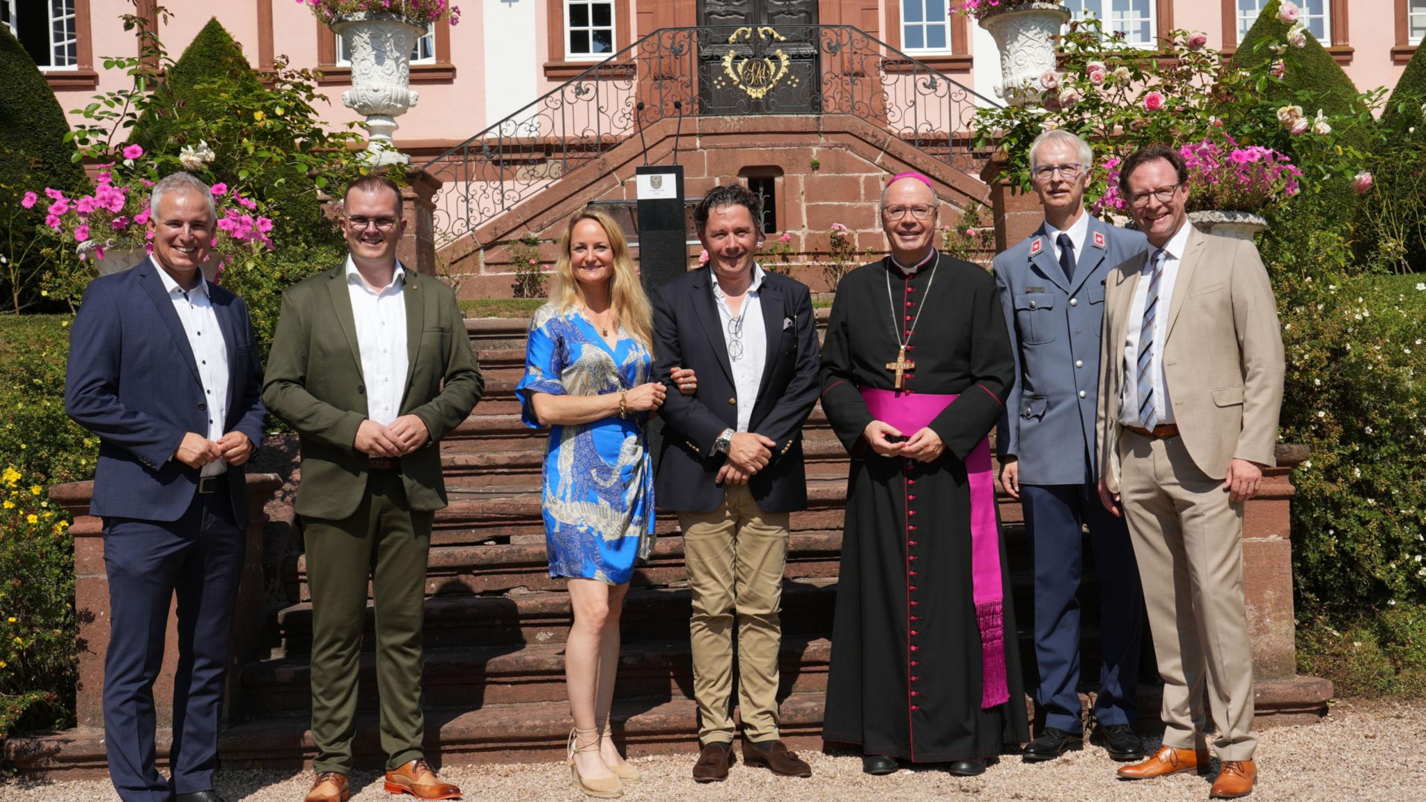 Vor dem Jubiläumsschloss (von links): Der Politiker Dennis Junk, Ortsbürgermeister Christoph Thieltges, Marina und Georg von Walderdorff, Bischof Dr. Stephan Acker-mann, Malteser-Geschäftsführer Werner Sonntag und Bürgermeister Andreas Ha-ckethal (Morbach).