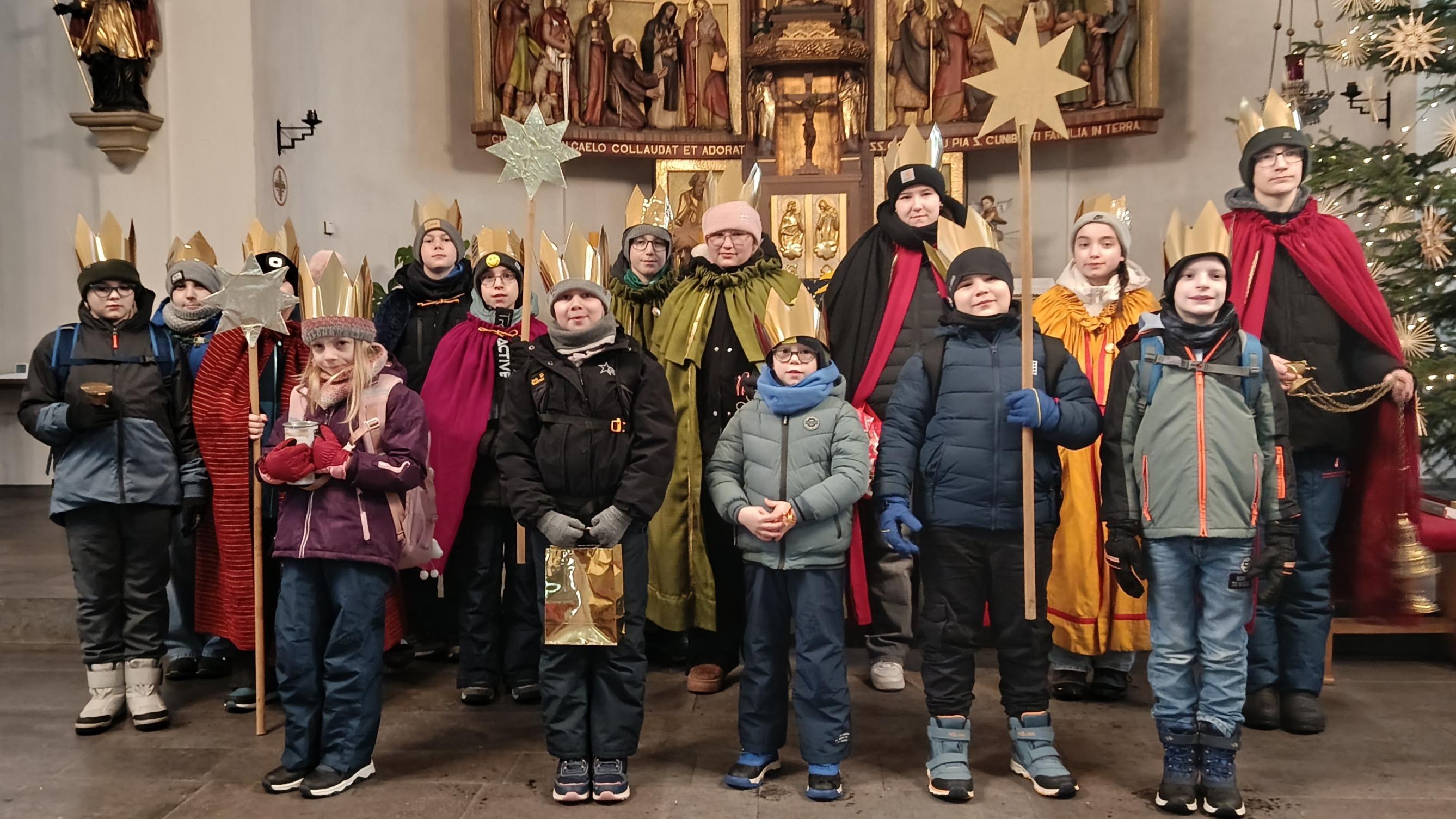 Kinder als Sternsinger am Altar